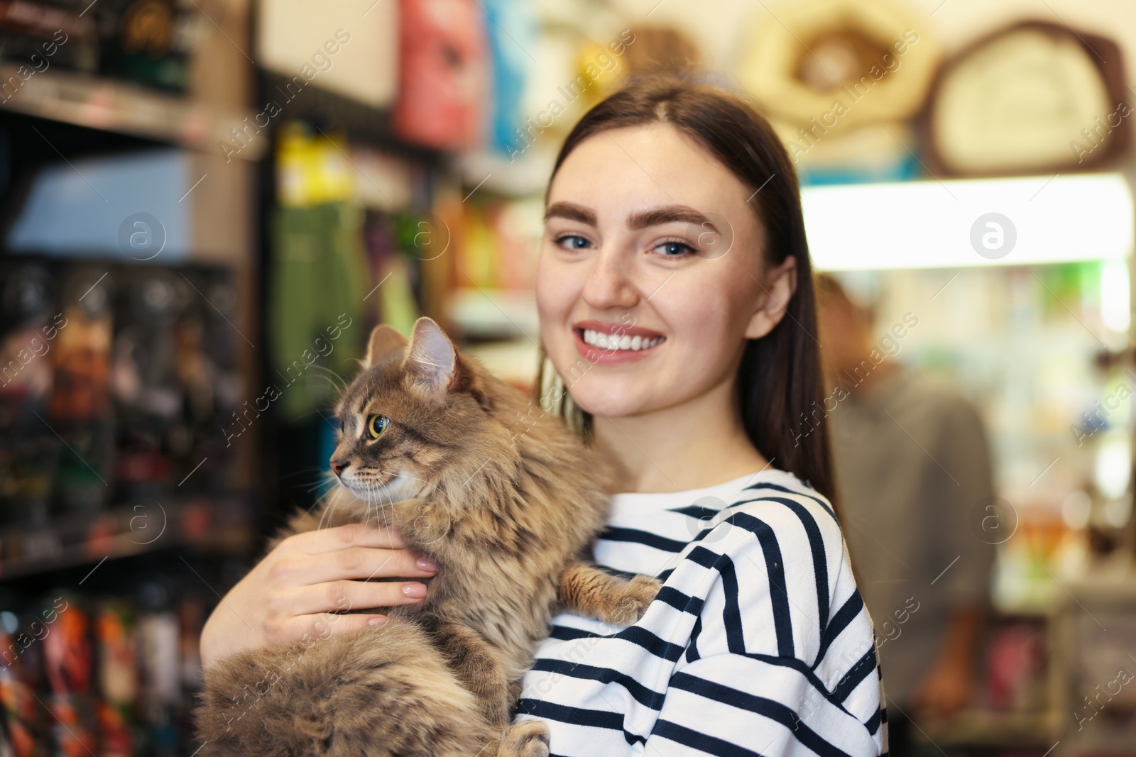 Photo of Woman with her cute cat in pet shop