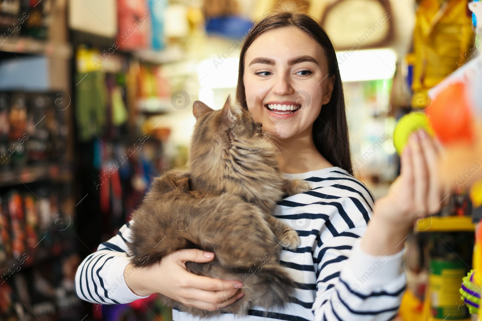 Photo of Woman with her cute cat in pet shop