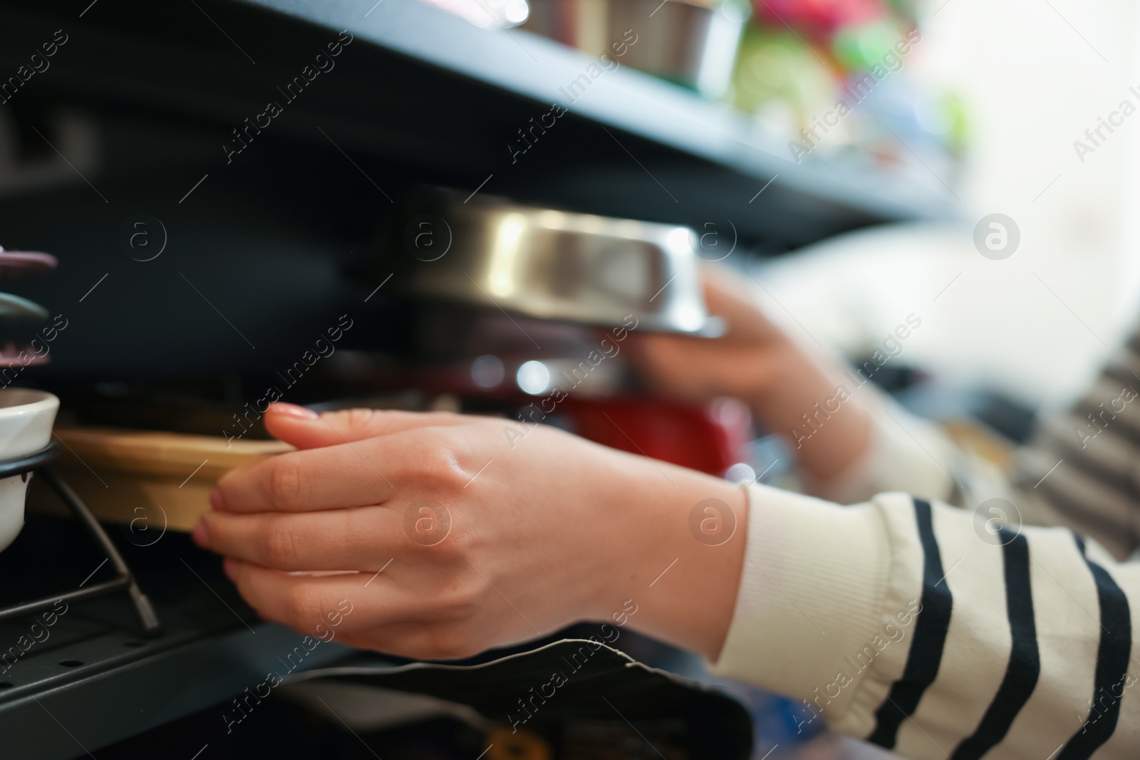 Photo of Woman choosing feeding bowl in pet shop, closeup