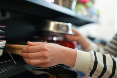 Photo of Woman choosing feeding bowl in pet shop, closeup