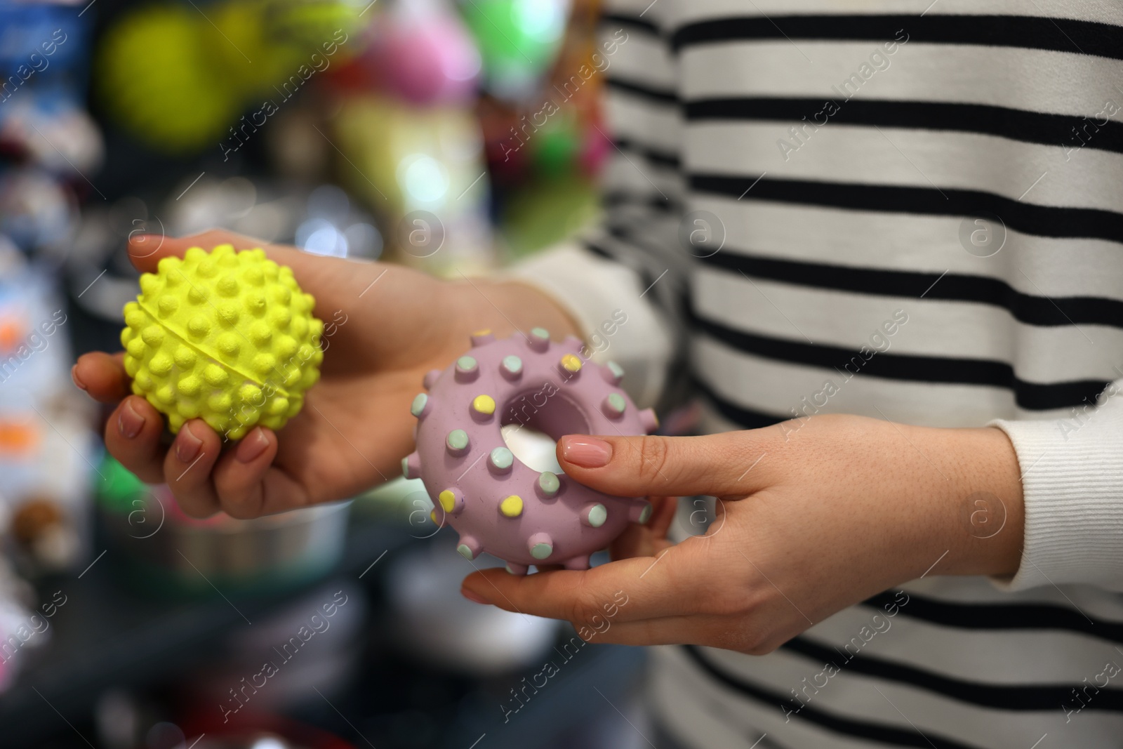 Photo of Woman with rubber toys in pet shop, closeup