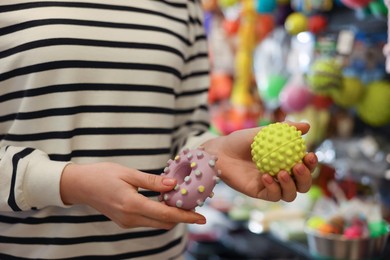 Photo of Woman with rubber toys in pet shop, closeup