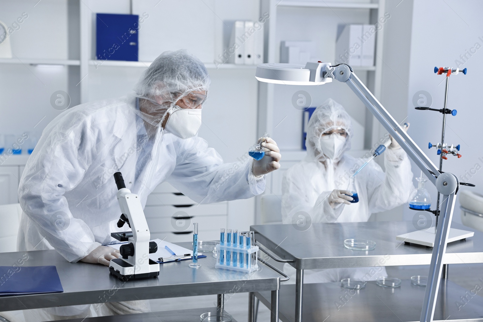 Photo of Scientists wearing protective suits while working in laboratory