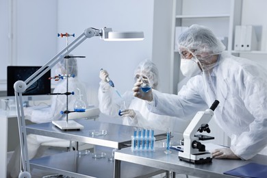 Photo of Scientists wearing protective suits while working in laboratory