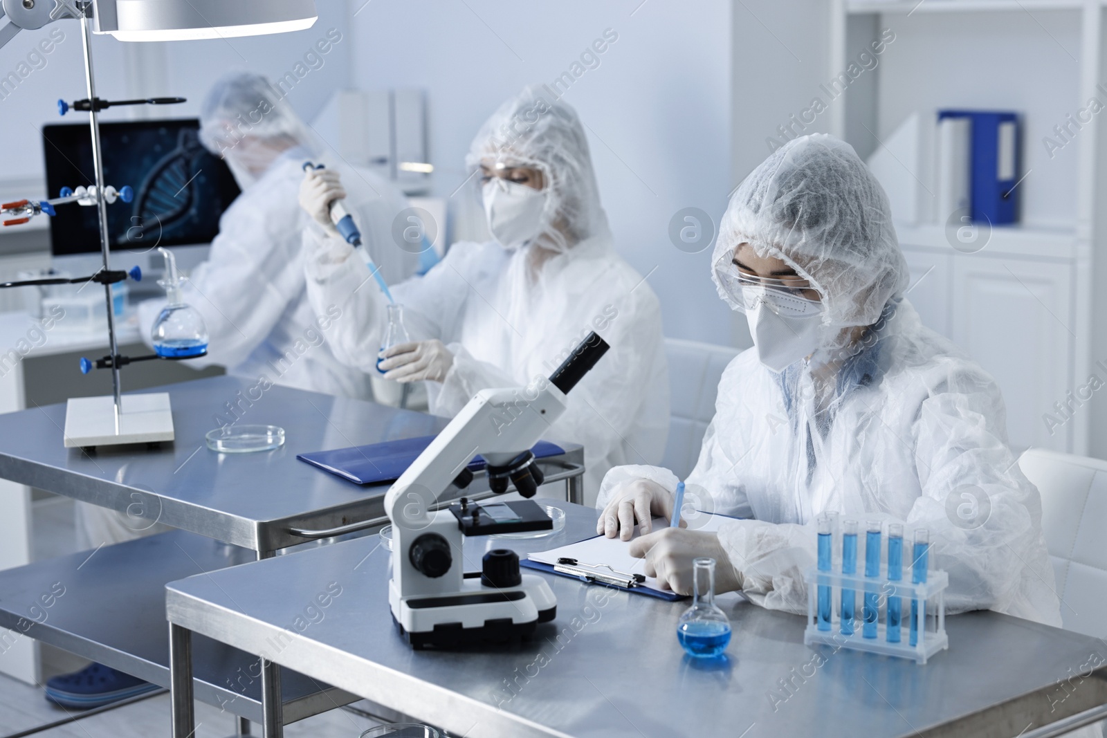 Photo of Scientists wearing protective suits while working in laboratory