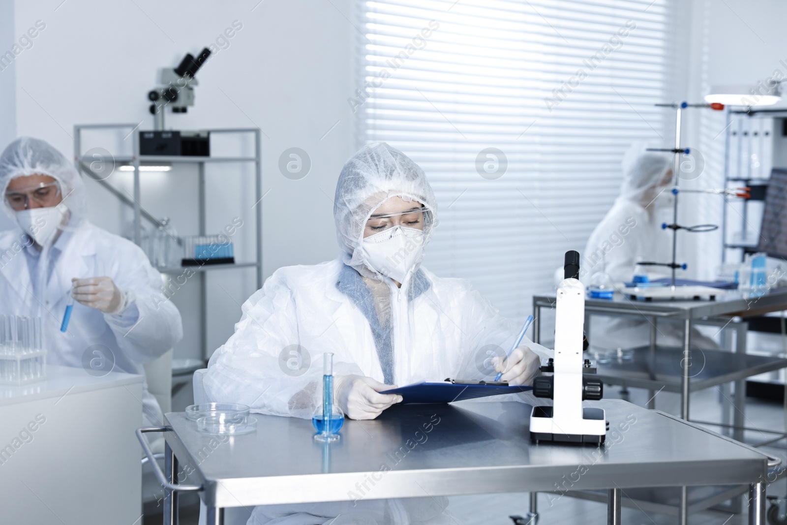 Photo of Scientists wearing protective suits while working in laboratory