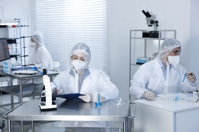 Photo of Scientists wearing protective suits while working in laboratory