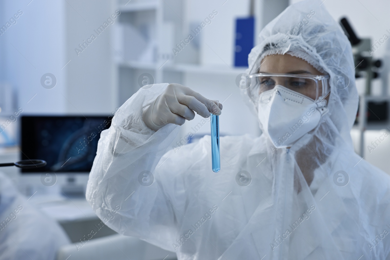 Photo of Scientist holding test tube with blue sample in laboratory