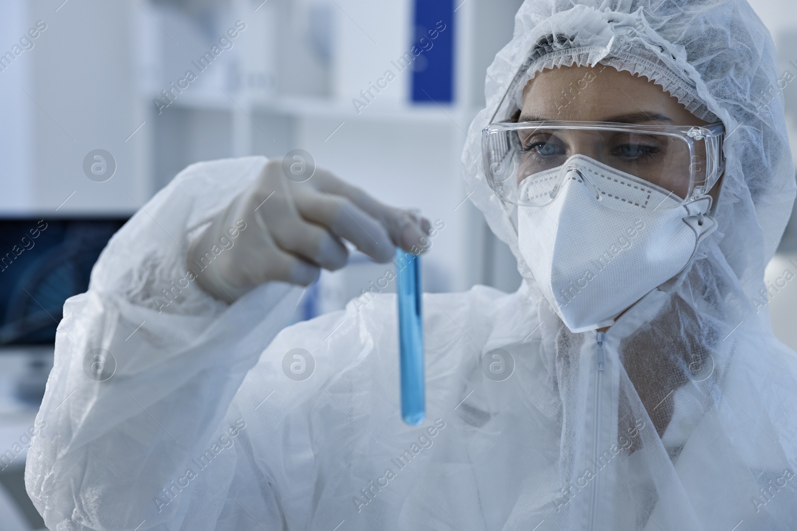 Photo of Scientist holding test tube with blue sample in laboratory