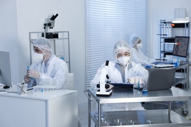 Photo of Scientists in protective suits working at laboratory