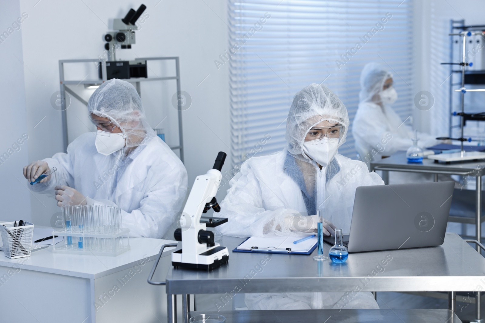 Photo of Scientists in protective suits working at laboratory