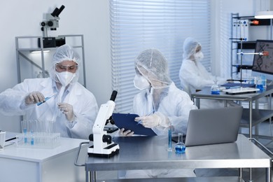 Photo of Scientists in protective suits working at laboratory