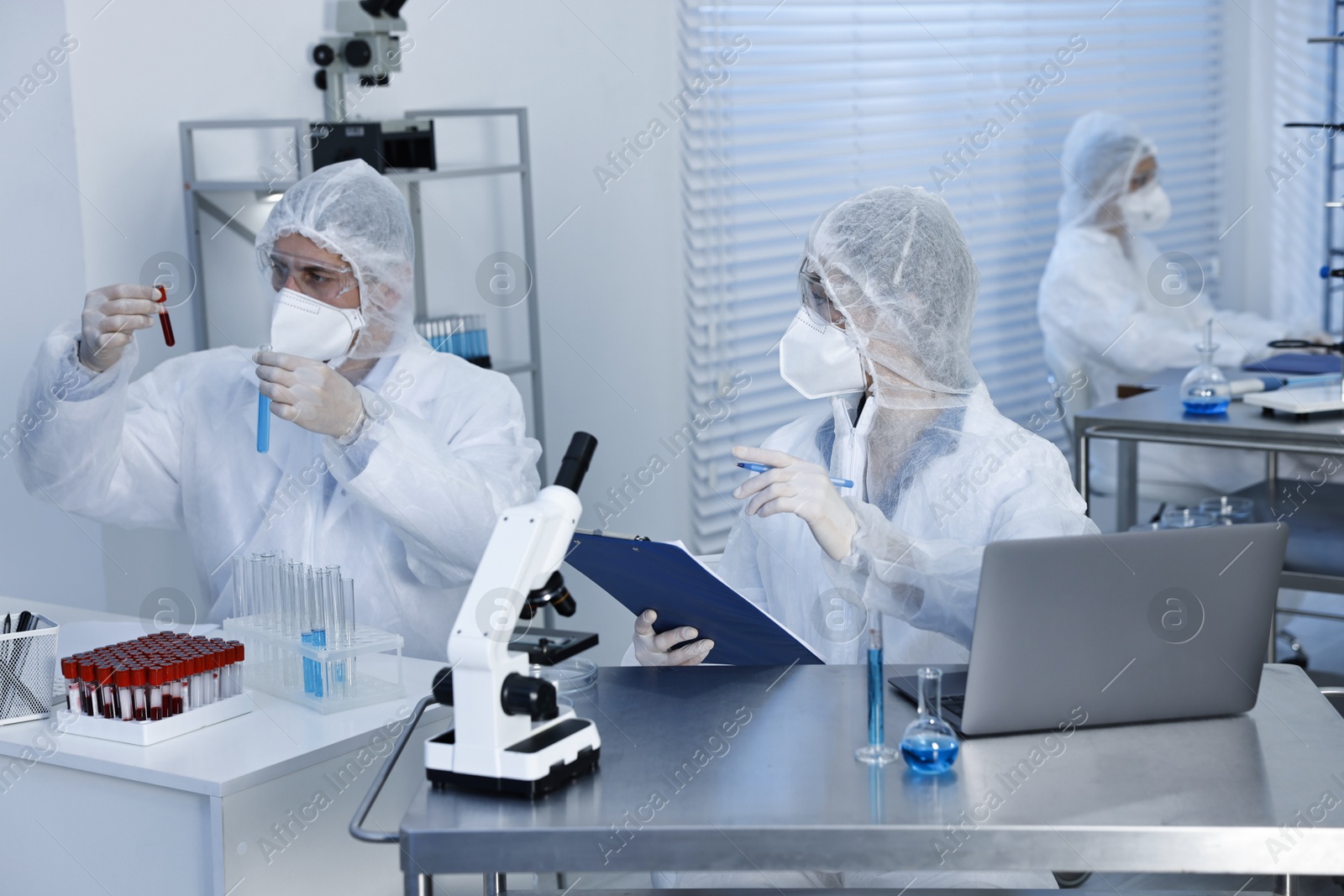 Photo of Scientists in protective suits working at laboratory