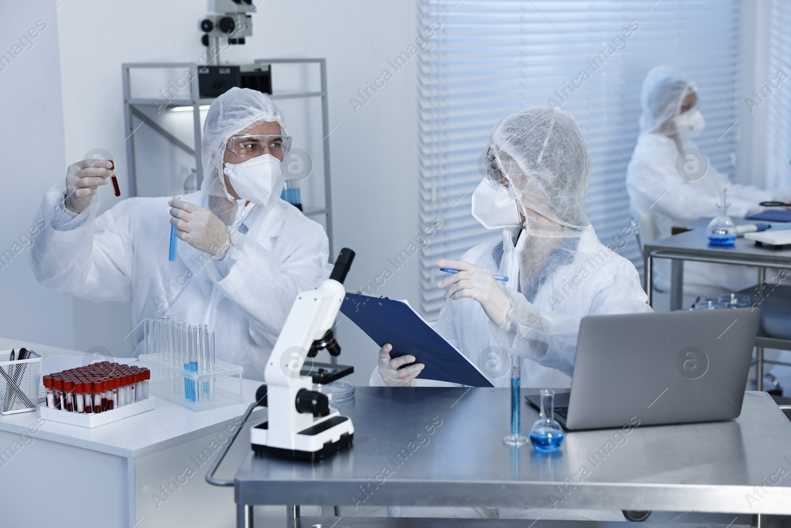 Photo of Scientists in protective suits working at laboratory