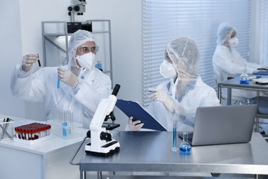 Photo of Scientists in protective suits working at laboratory