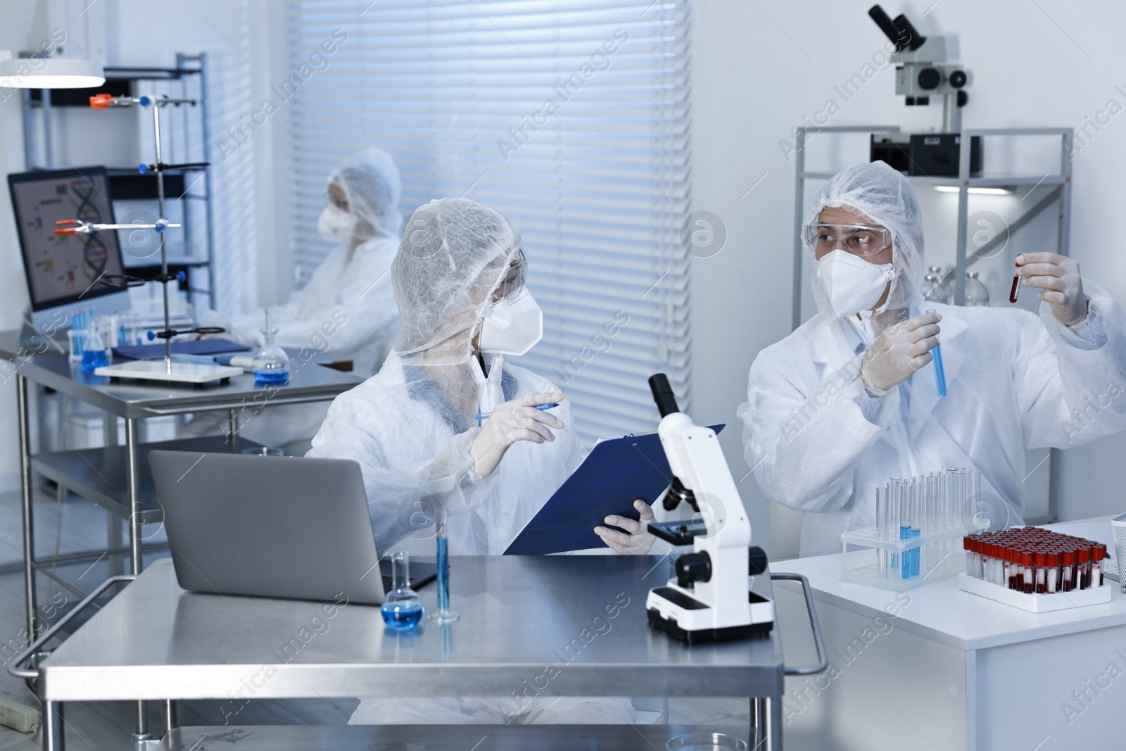 Photo of Scientists in protective suits working at laboratory