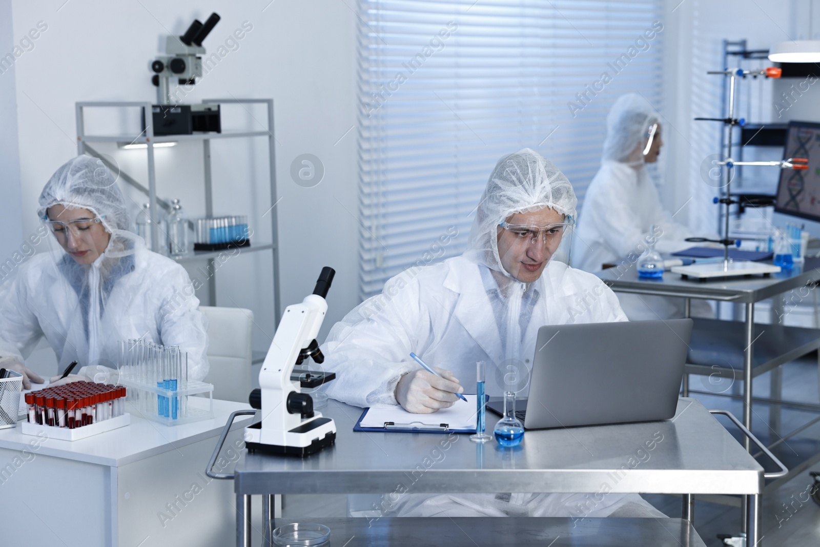 Photo of Scientists in protective suits working at laboratory