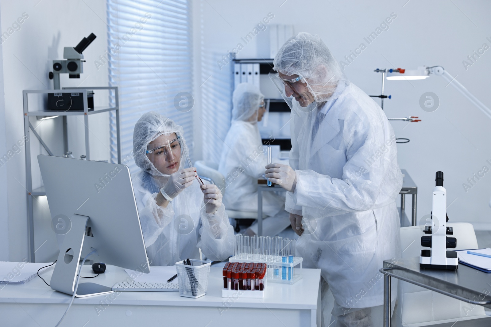 Photo of Scientists working with reagents and blood samples in laboratory