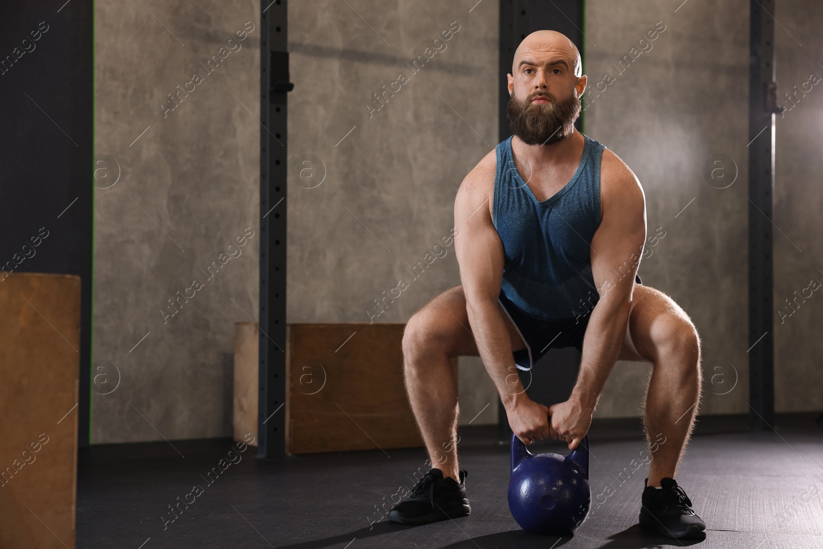 Photo of Sportsman doing kettlebell swing during crossfit workout in gym, space for text