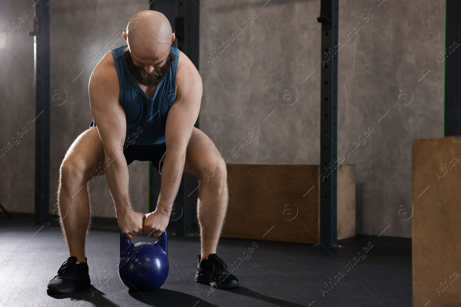 Photo of Sportsman doing kettlebell swing during crossfit workout in gym, space for text