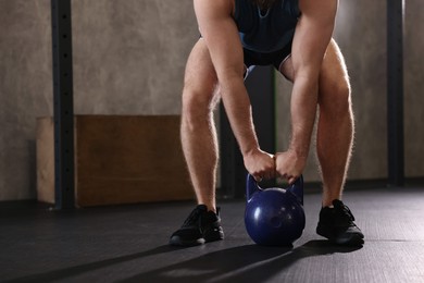 Photo of Sportsman doing kettlebell swing during crossfit workout in gym, closeup. Space for text