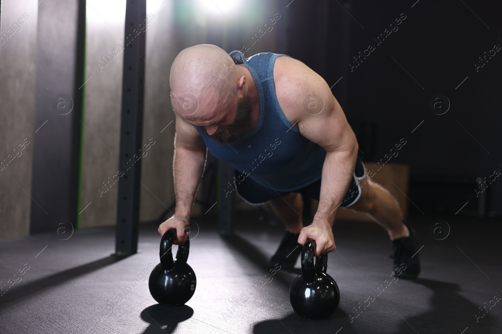 Photo of Sportsman doing kettlebell push up during crossfit workout in gym