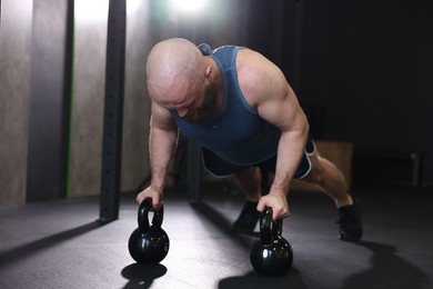 Photo of Sportsman doing kettlebell push up during crossfit workout in gym