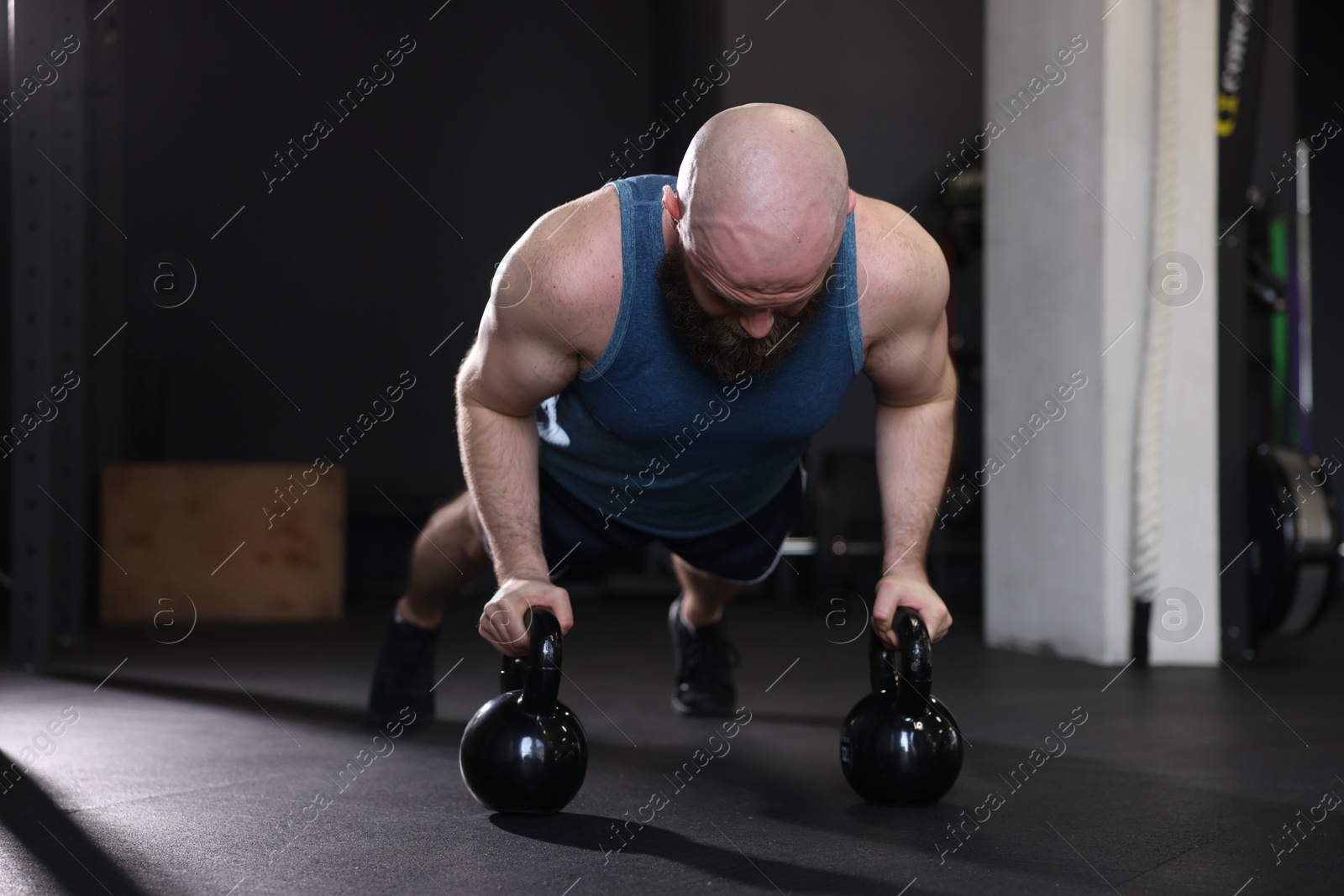 Photo of Sportsman doing kettlebell push up during crossfit workout in gym