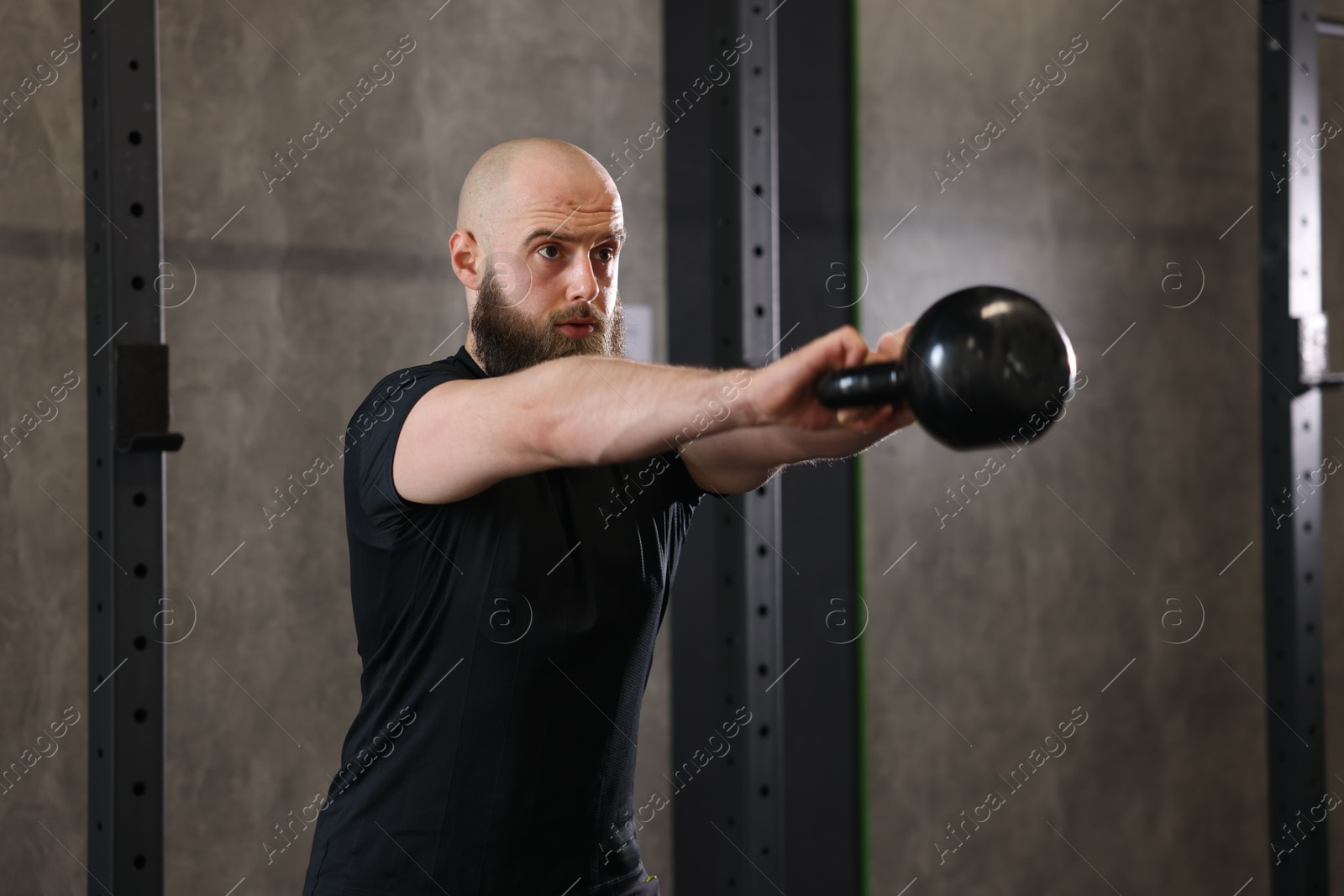 Photo of Sportsman doing kettlebell swing during crossfit workout in gym