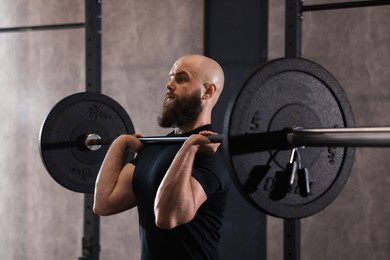 Photo of Sportsman with barbell during crossfit workout in gym