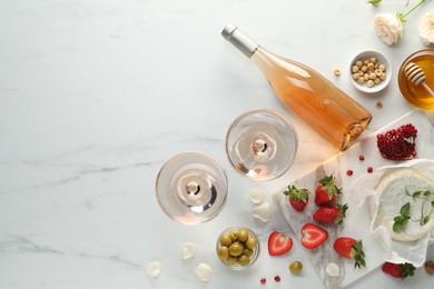 Photo of Flat lay composition with tasty rose wine and different food on white marble table. Space for text