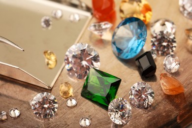 Photo of Beautiful colorful gemstones and beads scoop on table, closeup