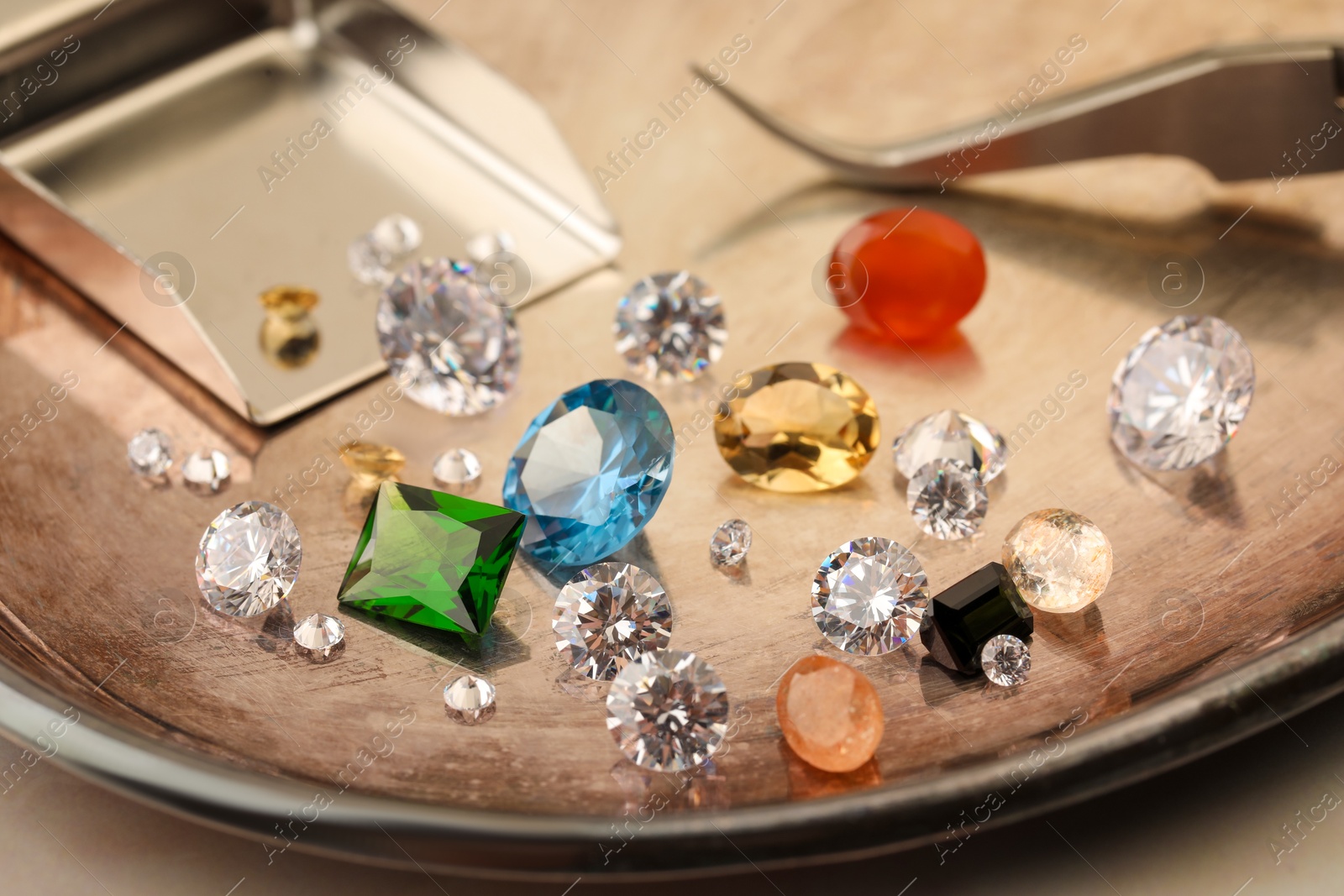 Photo of Tray with beautiful gemstones on light table, closeup