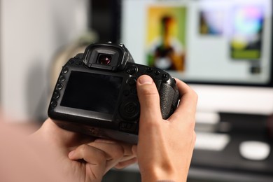 Photo of Photographer with professional camera at desk indoors, closeup