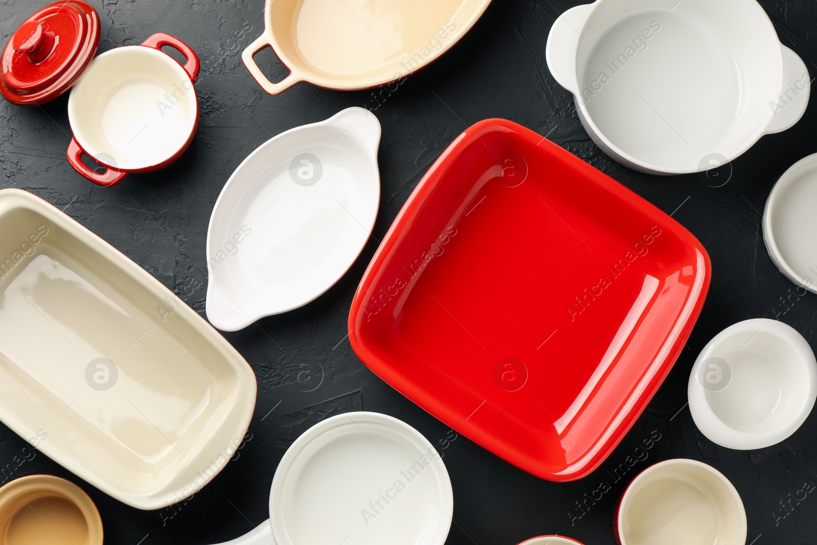 Photo of Many different casseroles on black table, flat lay