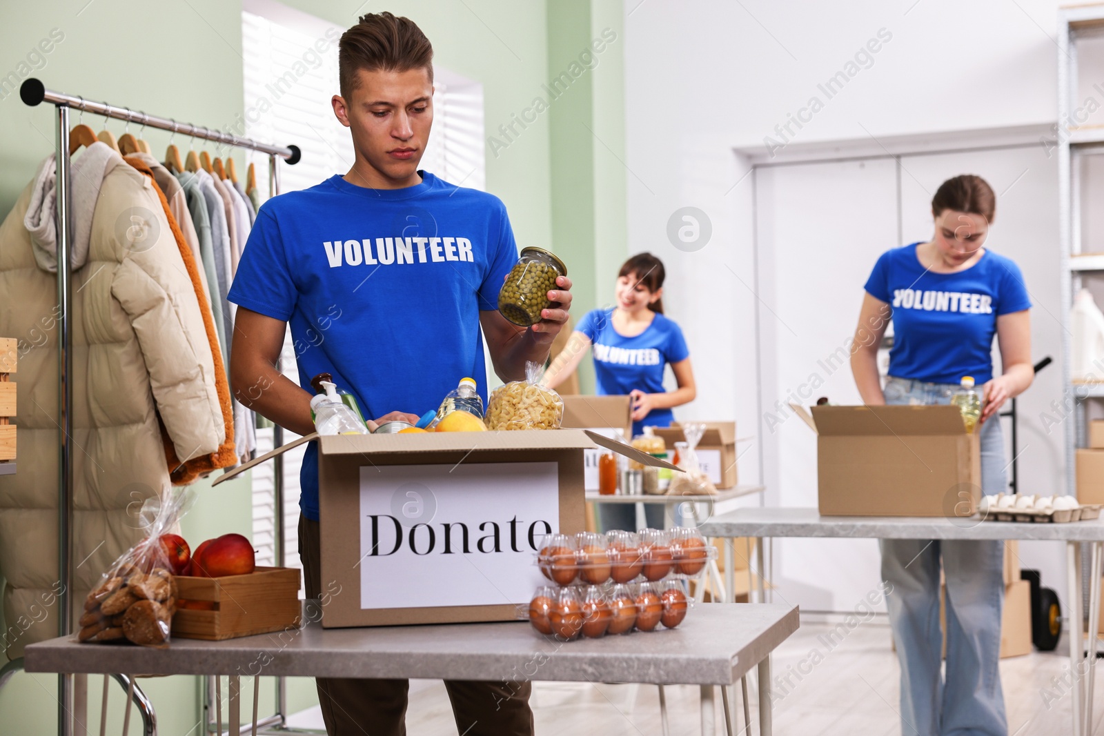 Photo of Volunteers packing food donations at tables indoors