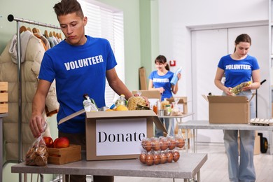 Photo of Volunteers packing food donations at tables indoors