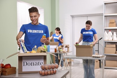 Photo of Volunteers packing food donations at tables indoors