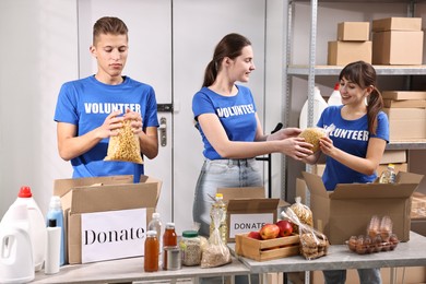 Photo of Volunteers packing food donations at tables indoors