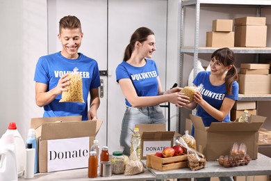 Photo of Volunteers packing food donations at tables indoors