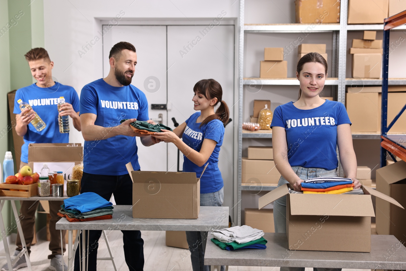 Photo of Group of volunteers packing donation goods at tables indoors