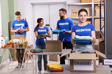 Photo of Group of volunteers packing donation goods at tables indoors