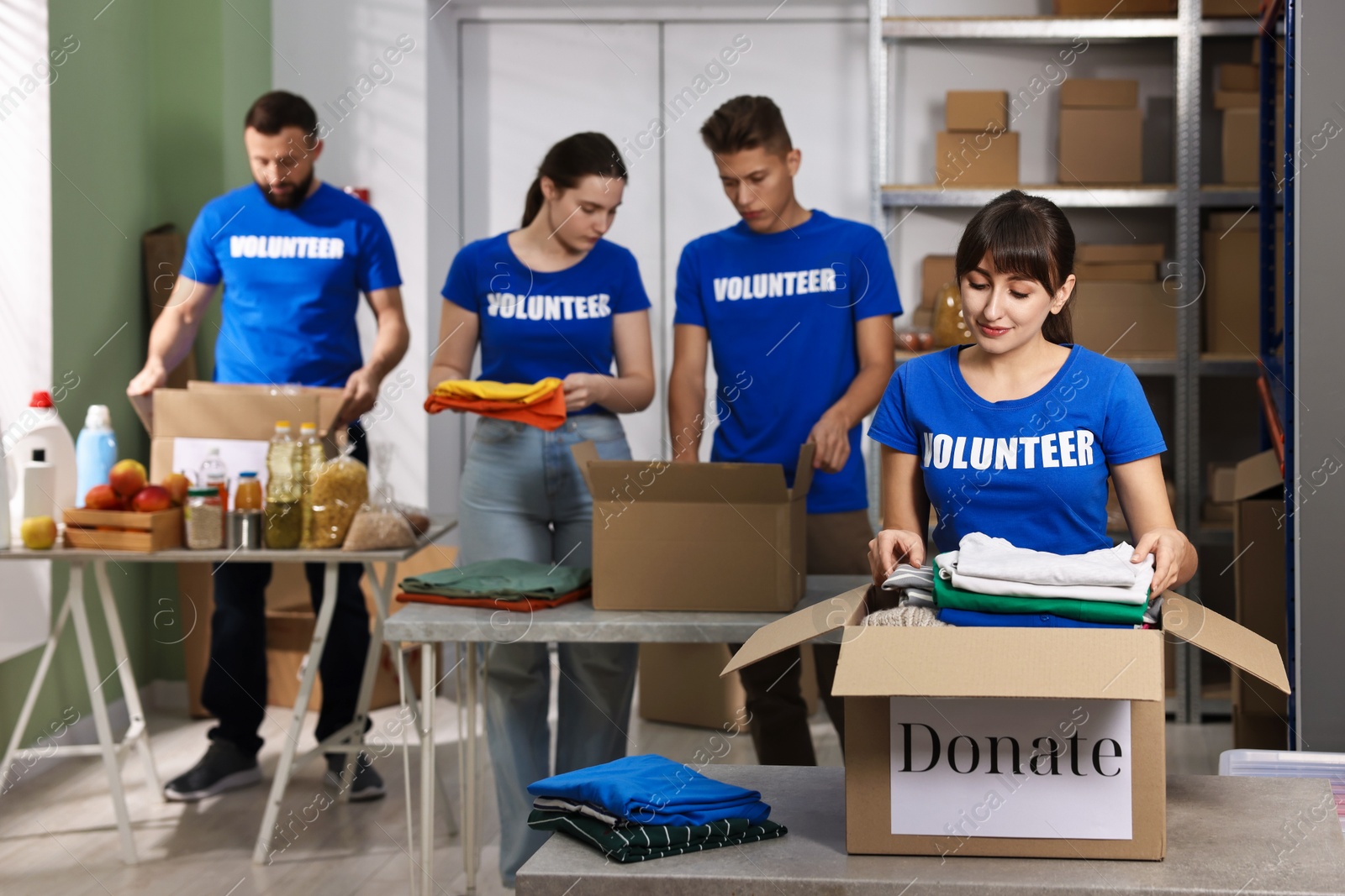 Photo of Group of volunteers packing donation goods at tables indoors