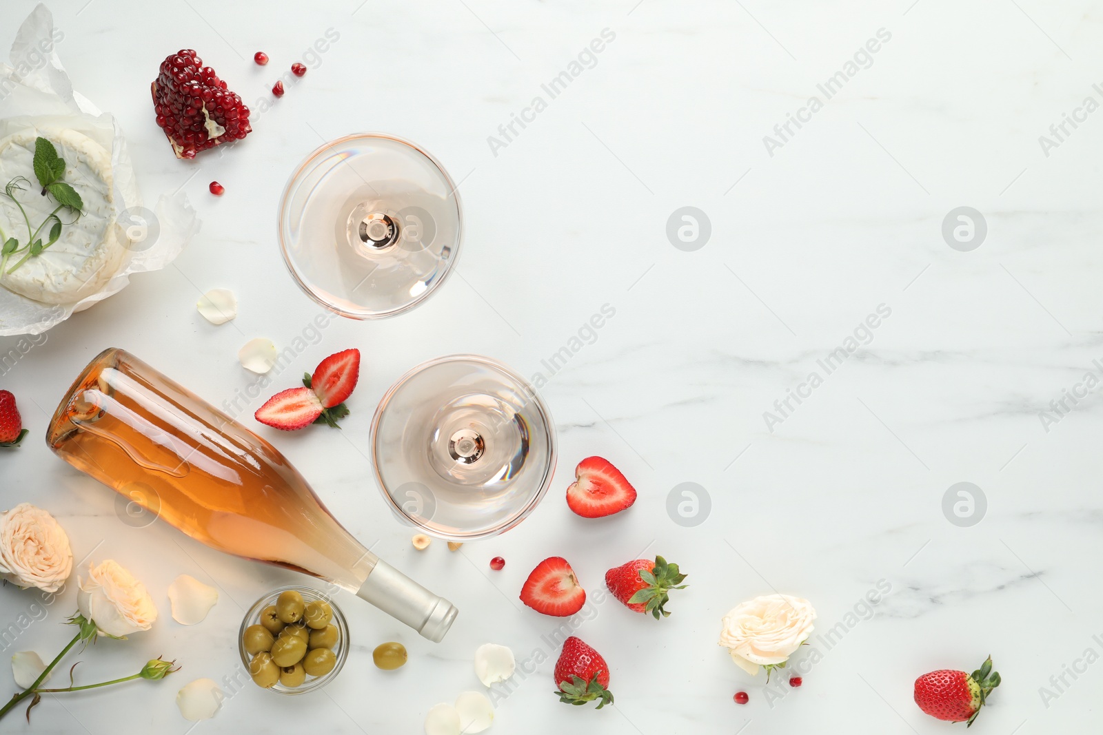 Photo of Flat lay composition with tasty rose wine and different food on white marble table. Space for text