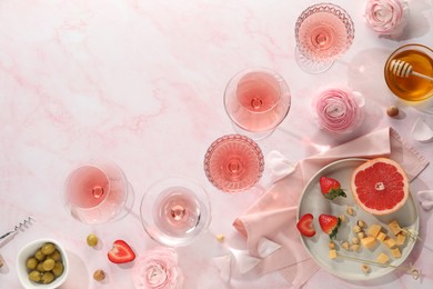 Photo of Flat lay composition with tasty rose wine and different food on pink marble table. Space for text