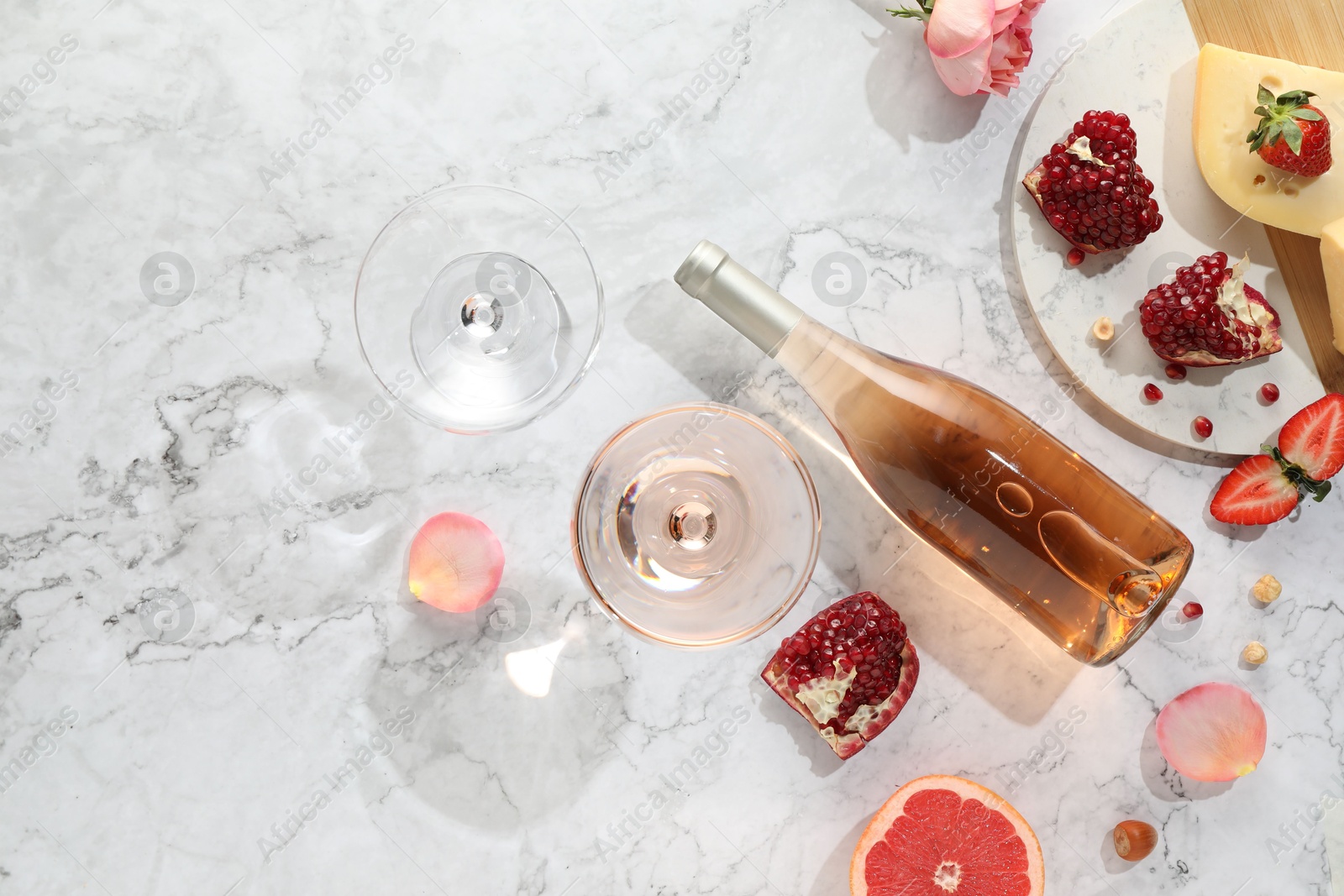 Photo of Flat lay composition with tasty rose wine and snacks on white marble table. Space for text