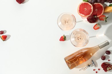 Photo of Flat lay composition with tasty rose wine and snacks on white table. Space for text