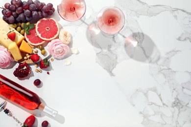 Photo of Flat lay composition with tasty rose wine and snacks on white marble table. Space for text