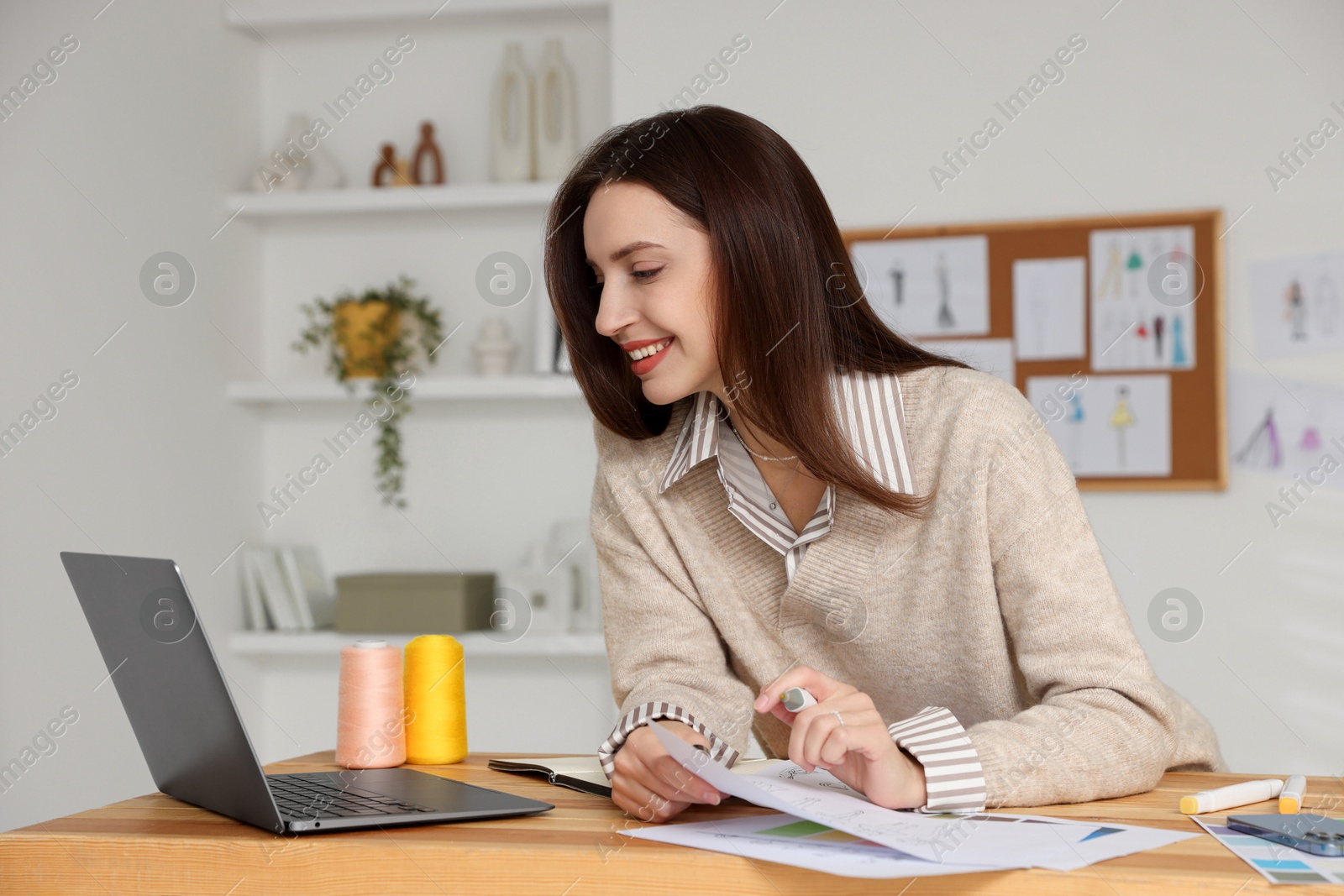 Photo of Fashion designer working at wooden table in workshop