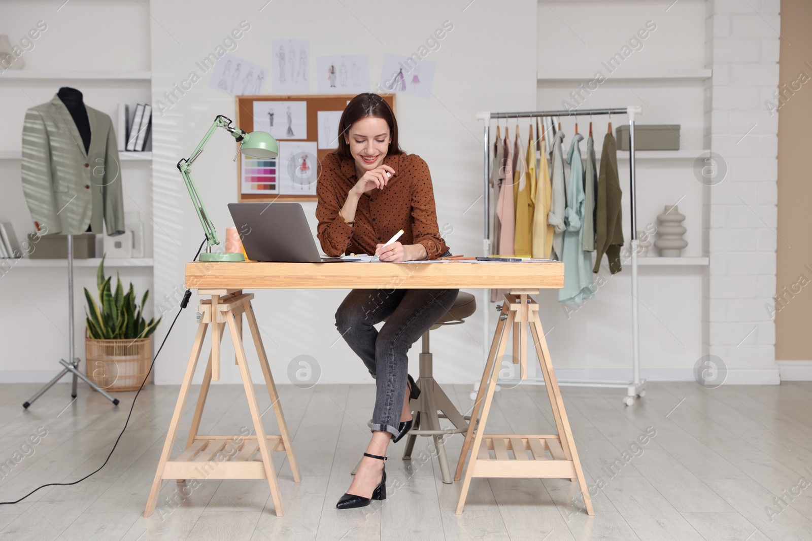 Photo of Fashion designer working at wooden table in workshop